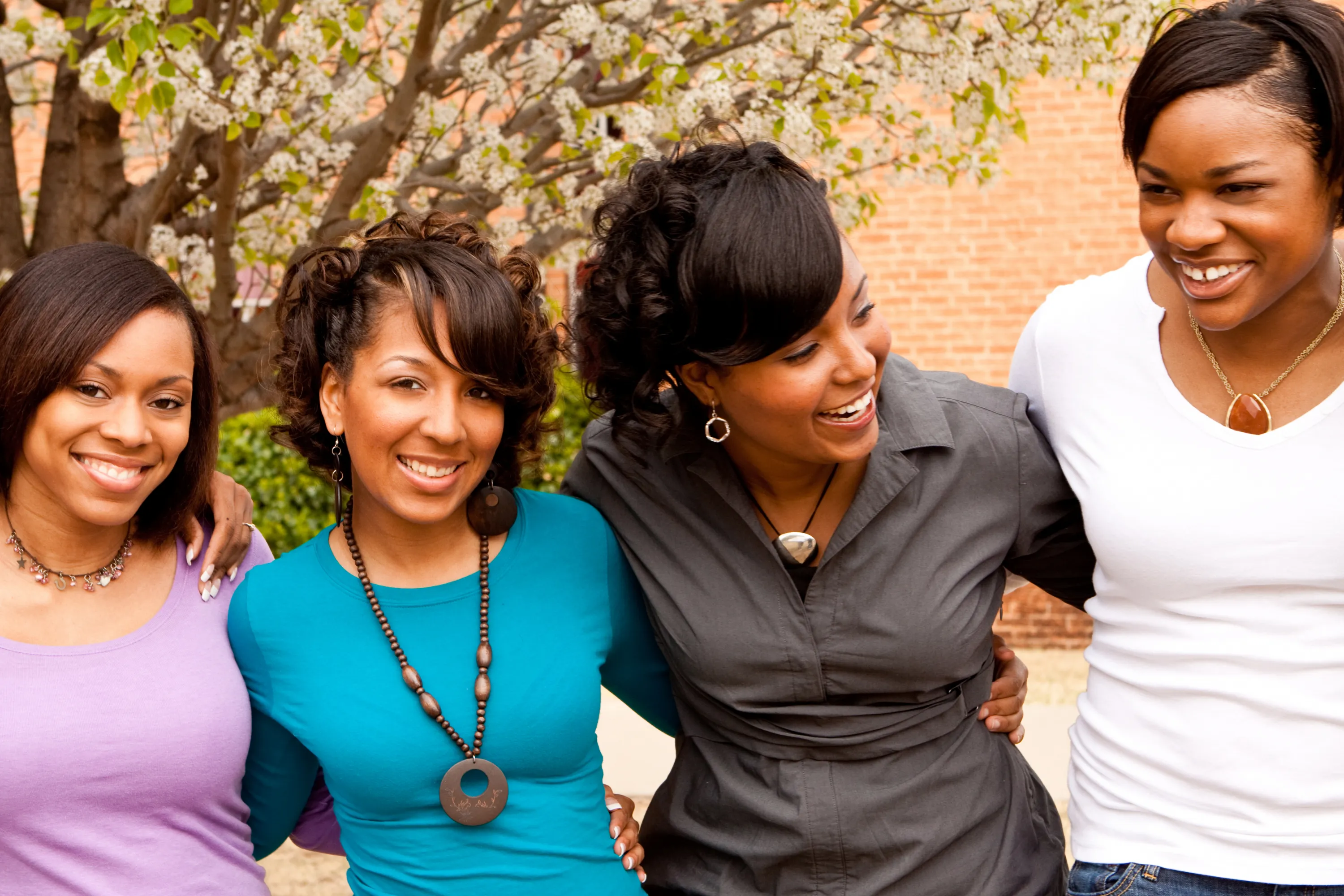 Photo of four women standing together and smiling